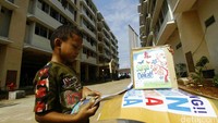 Seorang anak membaca buku di depan Rusun Cibesel.