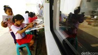 Beberapa anak asyik membaca di perpustakaan keliling.