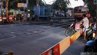 Laju kendaraan terhenti saat kereta api melintas di perlintasan Kramat Sentiong.