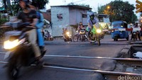 Beberapa pengendara sepeda motor nekat menerobos saat pintu perlintasan kereta tertutup.