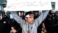 Demonstran membentangkan poster-poster tuntutan. Noah Berger/Reuters/detikFoto.