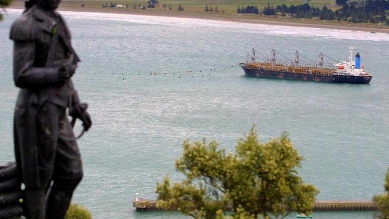 Patung James Cook A statue of British explorer Captain James Cook overlooks the grounded South Korean log carrier Jody F Millennium at Gisborne on the North Island, 13 February 2002 as fears mount that it may break up and spill 650 tonnes of heavy oil fuel. Ocean-going tugs are preparing to pull the 156-metre Panamanian registered bulk carrier off the sand ahead of forecast severe weather conditions. The ship became stuck fast on the beach that acquired world-wide fame during Millennium celebrations, as Gisborne was the first city to see the light of the new century, after being battered by a storm and huge swells on 06 February. AFP PHOTO/Dean TREML / AFP PHOTO / DEAN TREML