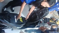 Mahasiswi ITS membuka komponen Gesits saat motor diperlihatkan di Surabaya. Foto: Imam Wahyudiyanto