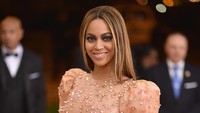 Ia memadukannya dengan clutch bag warna senada. Dimitrios Kambouris/Getty Images/detikFoto.