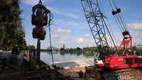 Alat berat menancapkan turap setinggi 12 meter di sekeliling danau.