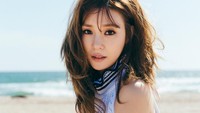 Duduk di atas pasir di pinggir pantai, tato Tiffany ngintip. (SM Entertainment)
