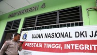 Polisi berjaga-jaga di depan sekolah SMP Negeri 4 Jakarta Pusat yang ruangannya akan dipergunakan Ujian Nasional Tingkat SMP.
