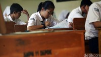 Seorang siswi serius membaca soal Ujian Nasional.