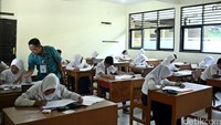 Seorang guru mengawasi jalannya Ujian Nasional.