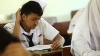 Seorang siswa serius membaca soal Ujian Nasional.