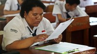 Seorang siswi serius mengerjakan soal Ujian Nasional.