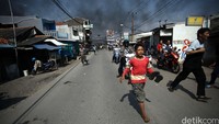 Warga dan anak-anak berlarian saat kericuhan terjadi.