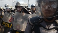 Polisi siaga dengan tameng dan helm.
