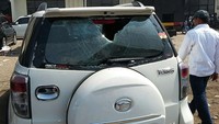 Kaca mobil pecah terkena lemparan batu.