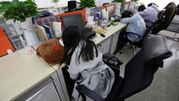 Beberapa pekerja tidur di meja kerjanya. Jason Lee/Reuters/detikFoto.
