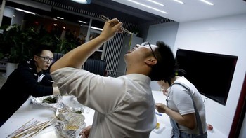 Menikmati makan malam bersama dengan sesama karyawan Goopal Group. Foto: Reuters/Jason Lee