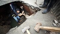 Para pekerja memperbaiki jalan yang ambles.