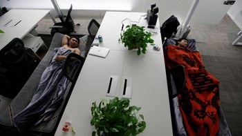 Dua karyawan BaishanCloud, mengambil waktu untuk tidur siang di kantor.  Foto: Reuters/Jason Lee
