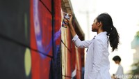 Bunga, salah satu pendiri Ladies on Wall membuat huruf L dan A.