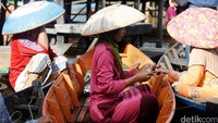 Seorang pedagang menghitung uang pecahan yang telah ditukarkan di kas terapung.