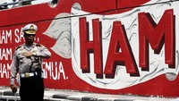 Seorang polisi mengatur lalu lintas di depan mural Tragedi 12 Mei.