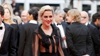 Mantan kekasih Robert Pattinson itu kenakan blus hitam transparan yang dipadu rok hitam bermotif hijau dan heels hitam. Andreas Rentz/Getty Images/detikFoto.