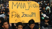 Massa membawa poster menagih janji Jokowi.