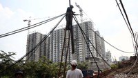 Pekerja memindahkan kabel-kabel dan tiang listrik.