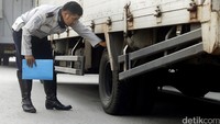 Petugas Dishub DKI Jakarta, tengah memeriksa ban dari kendaraan truk barang.