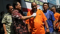 Para tersangka dihadirkan dengan tangan diborgol.