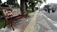 Jalur pejalan kaki tersebut berlantai ubin dan konblok yang disusun dengan motif tertentu.