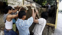 Pedagang memindahkan batu-batu hias dengan truk.