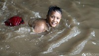 Seorang anak asyik bermain air.