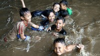 Anak-anak tampak ceria bermain banjir.