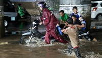 Sejumlah anak membantu mendorong motor yang mogok.