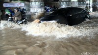 Pengendara mobil nekat menerobos genangan.