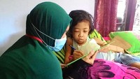 Fhristy tetap semangat mengerjakan soal ujian nasional di rumahnya, Jalan Galunggung, Kelurahan Triwung kidul, Kecamatan Kademangan Kota Probolinggo. Ist/Esti Setyarini.