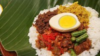 Ini adalah Nasi Bogana yang berasal dari Tegal, Jawa Tengah. Nasi ini biasanya dibungkus daun pisang dan disajikan dengan ayam suwir, telur pindang, tempe, dan sambal goreng. Foto: detikFood