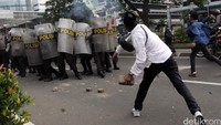 Sementara massa melempari polisi dengan batu dan kayu.