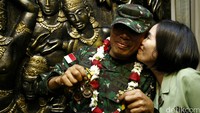 Prajurit TNI AD, Letda Appolta Siahaan mendapatkan ciuman dari sang istri. 