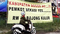 Pengendara sepeda motor melintas di depan spanduk kekecewaan warga terhadap pemerintah Kabupaten Bogor.