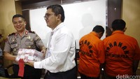 Direktur Tipideksus Bareskrim Brigjen Agung Setya (kiri) menunjukkan uang palsu yang diamankan dari kedua tersangka.