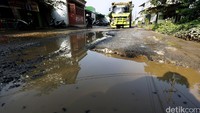Jalan berlubang disana-sini menimbulkan kubangan usai diguyur hujan. 