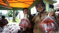 Seorang warga menunjukkan cabai yang dibelinya. Di pasar murah ini, cabai dijual dengan harga Rp 15.000/kg. Berbeda dengan di pasar yang harganya mencapai Rp 22.000/kg.
