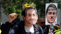 Seorang demonstran memakai topeng bergambar Nicolas Sarkozy. Reuters/Jean-Paul Pelissier/detikFoto.