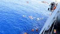 Kapal patroli angkatan laut Italia The Bettica berusaha melakukan evakuasi dengan melemparkan pelampung. Marina Militare/Handout via Reuters.