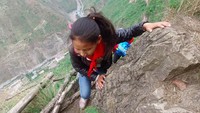 Penduduk desa yang tinggal di puncak bukit setinggi 800 meter di China barat daya jadi sangat terkenal. Karena, untuk mencapai desa ini harus meniti tangga di pinggir jurang (Foto: Beijing News/Chen Jie)