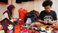 Ozza dan Icha merampungkan kerajinan miniatur Ondel-ondel yang terbuat dari botol bekas air mineral.