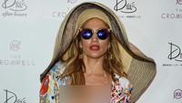 Ia juga memadukan gayanya dengan topi lebar, kacamata, anting, gelang emas dan cincin. Ethan Miller/Getty Images/detikFoto.