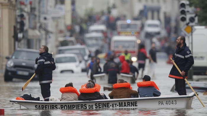 French firefighters on small boats evacuate residents from a flooded area after heavy rainfall in Nemours, France, June 1, 2016. REUTERS/Christian Hartmann